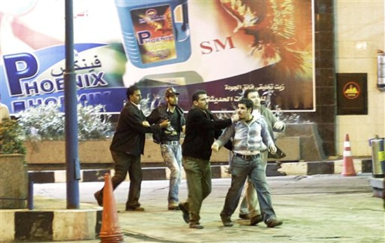 Egyptian plainclothes police arrest two Coptic Christian youths, who were part of a noisy protest at night near the bombed church, in Alexandria, Egypt Sunday, Jan. 2, 2011. The police investigation into the New Year's church bombing that killed 21 people is focusing on a local group of Islamic hard-liners inspired by al-Qaida, Egyptian security officials said Sunday. (AP Photo/Ben Curtis)
